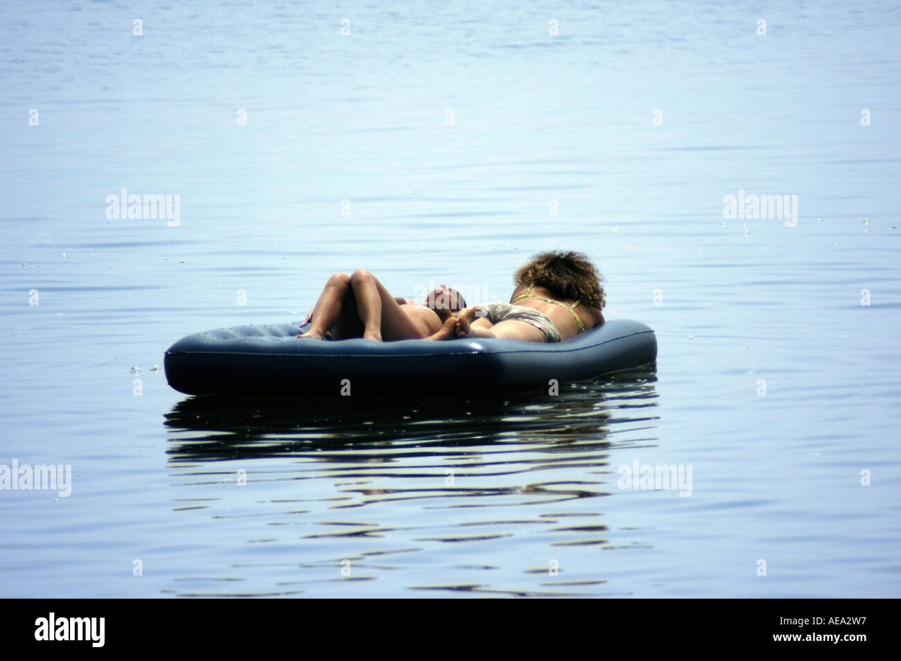 2 women floating with an air mattress on a calm water lake Israel Stock  Photo - Alamy