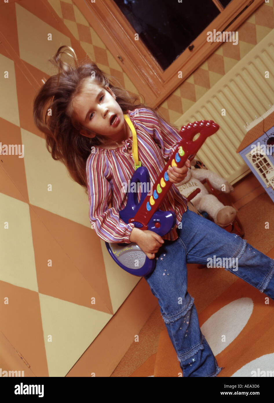 Little girl playing at being a pop rock star in her playroom Stock ...