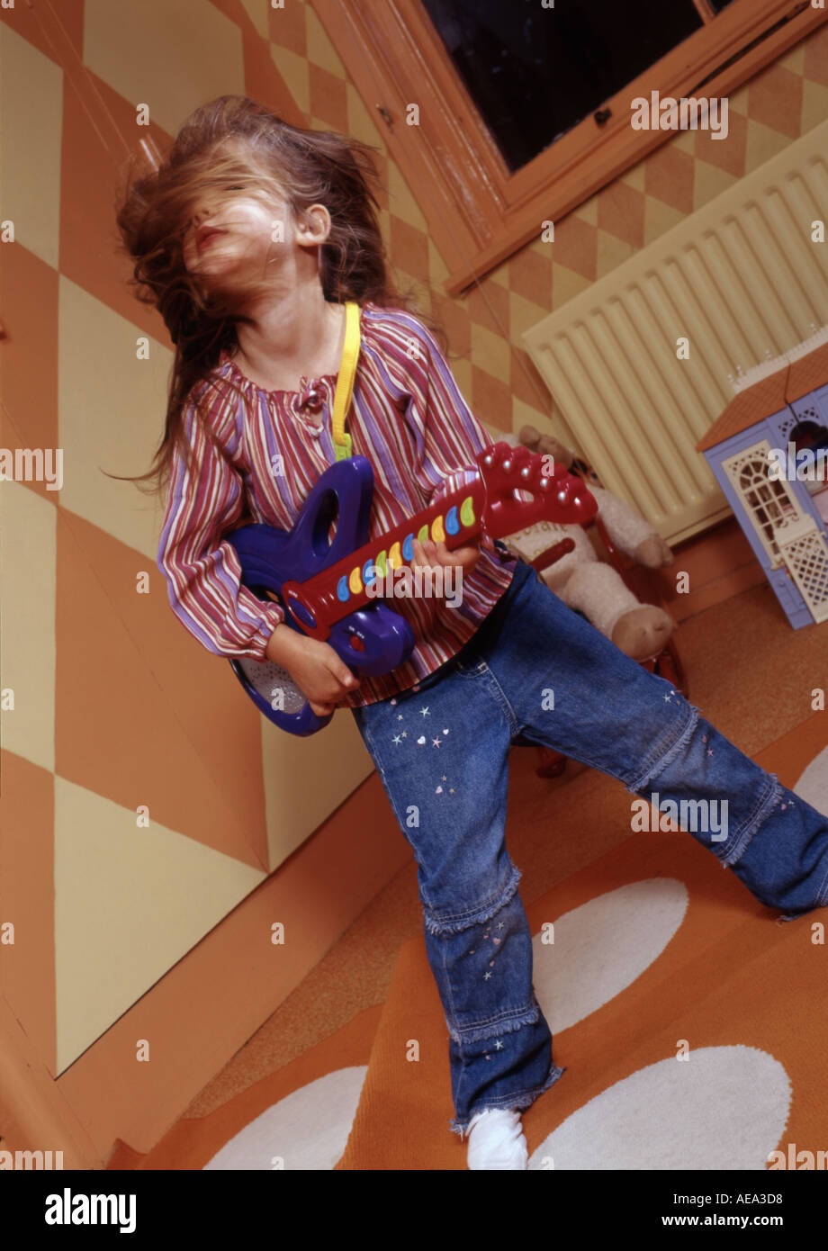 Little girl playing at being a pop rock star in her playroom Stock ...