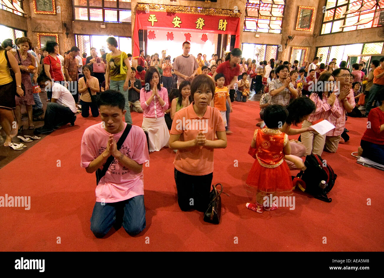 People praying for good fortune inside a Chinese temple in Singapore during the Chinese New Year celebrations. Stock Photo
