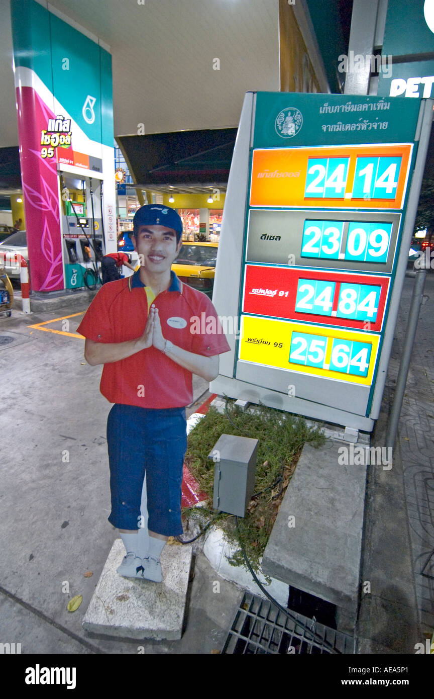 Price board at the entrance of a petrol station, with a welcoming figure doing a wai salute,  in Bangkok, Thailand. Stock Photo