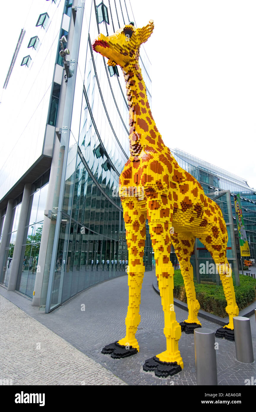 large figure TOY Giraffe made of lego brick ahead of SONY CENTER BERLIN reflections glass building front facade Stock Photo