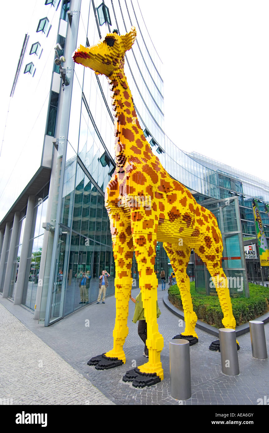 large figure TOY Giraffe made of lego brick ahead of SONY CENTER BERLIN reflections glass building front facade Stock Photo