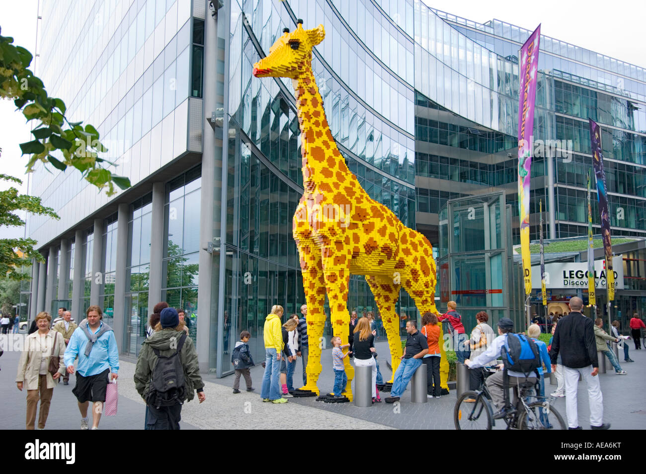 large figure TOY Giraffe made of lego brick ahead of SONY CENTER BERLIN people looking Stock Photo