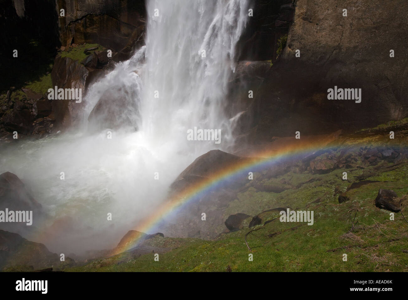 A rainbow forms at VERNAL FALLS which drops 317 feet during the SPRING run off YOSEMITE NATIONAL PARK CALIFORNIA Stock Photo