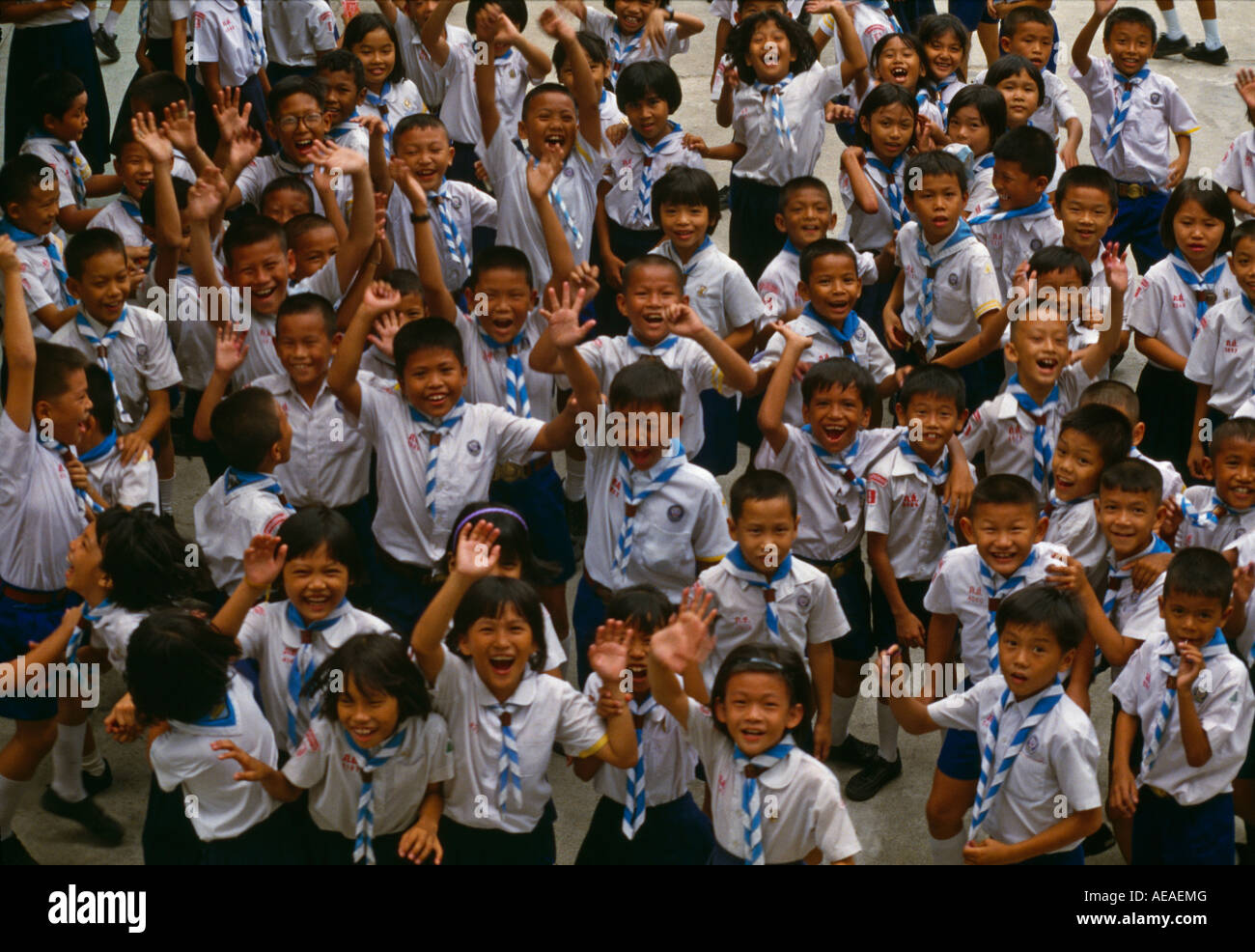 Bangkok school children jumping and smiling at the camera, Thailand. Stock Photo
