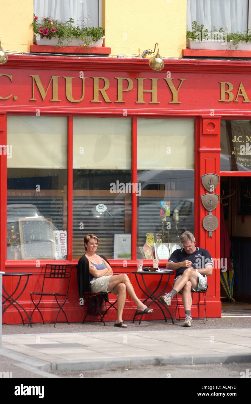 murphy's bar Macroom Ireland - two people sitting at table outside pub enjoying pints of beer on a warm sunny afternoon in june Stock Photo