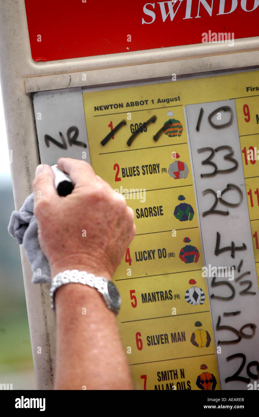 A bookies hands writing odds on a board at a racecourse Stock Photo