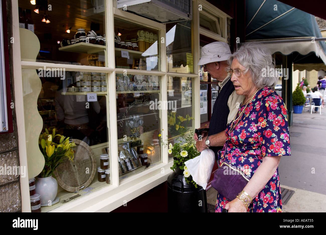 Elderly couple look in a shop window Tetbury England Stock Photo