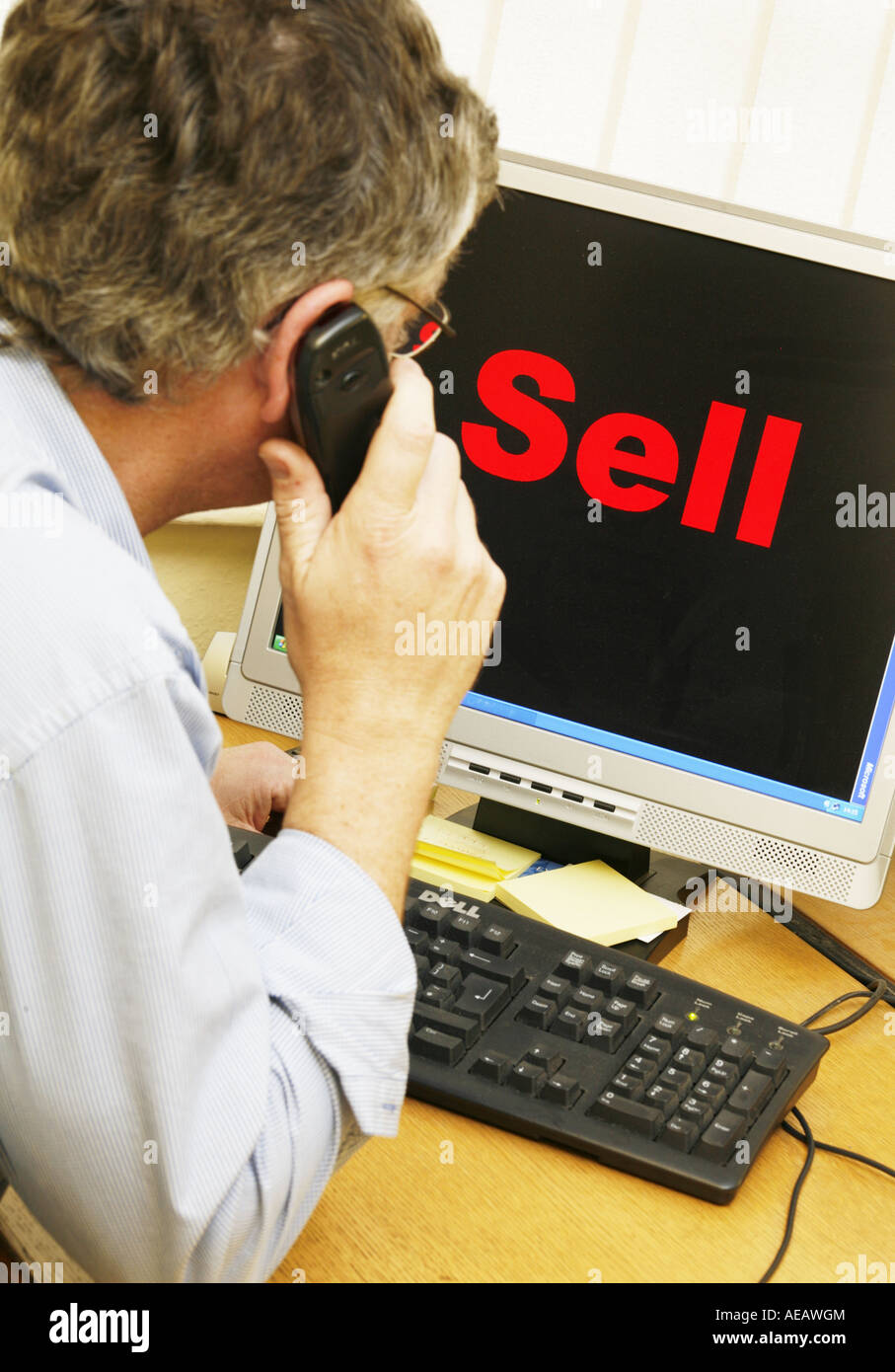 Sell sign on computer screen with trader looking on. Model Released