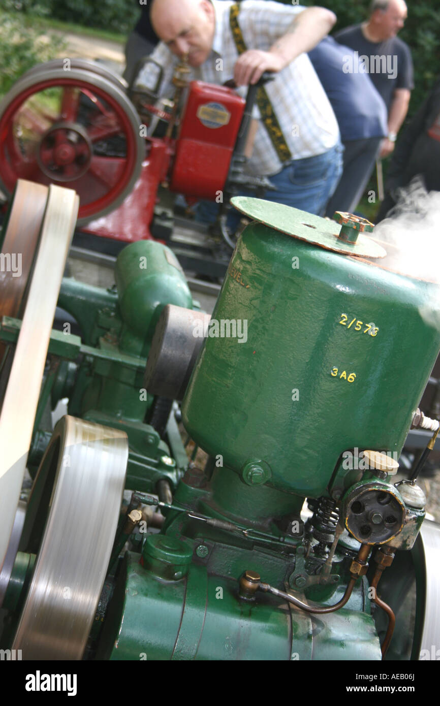 Stationary engine enthusiast tending to his engine at a show in County