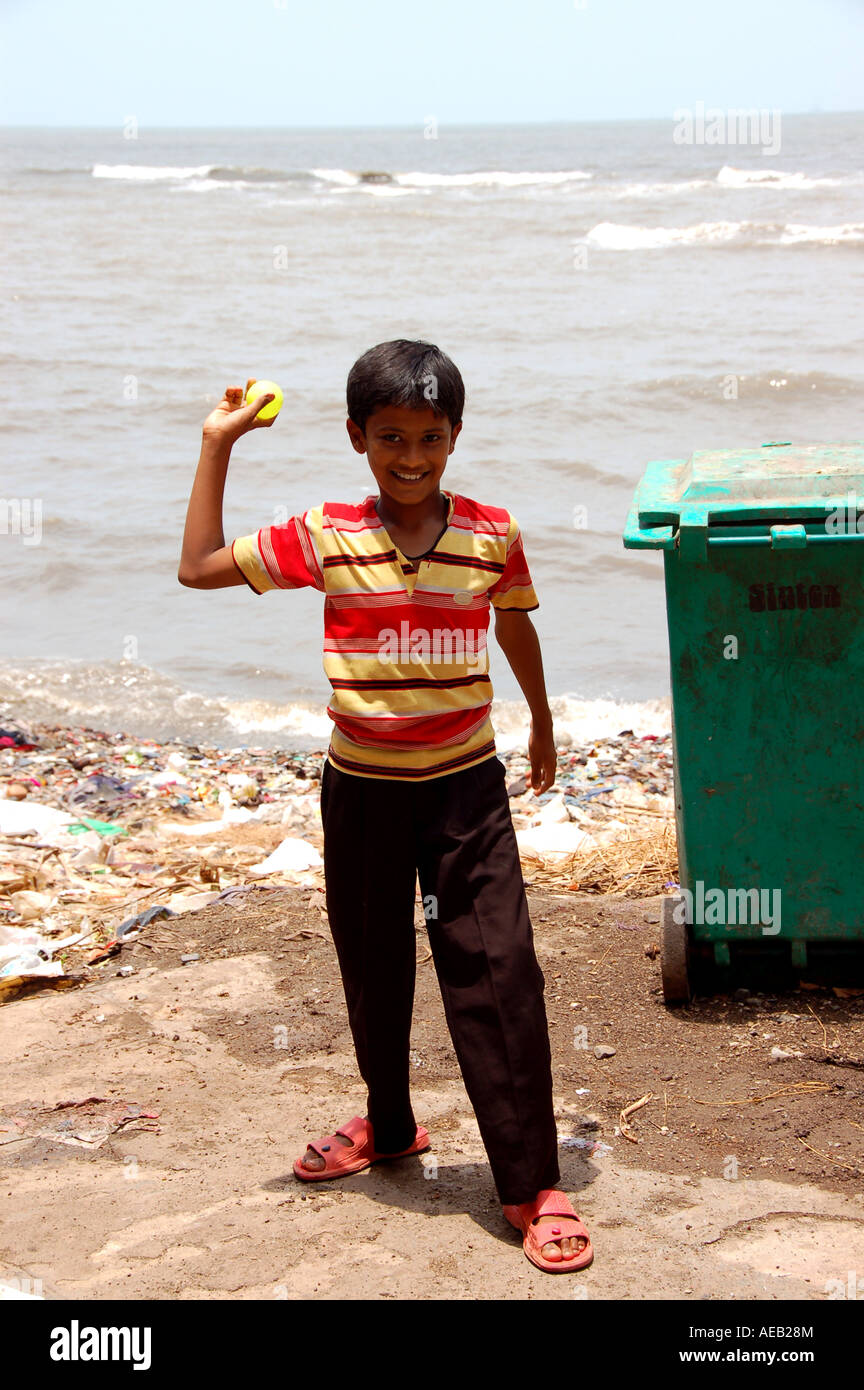 Happy, smiling Indian boy playing cricket in street in Mumbai /Bombay, India Stock Photo