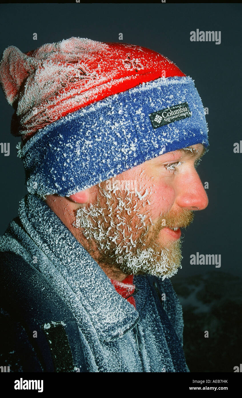 A fell walker on the summit of Helvellyn Lake district, UK, in winter