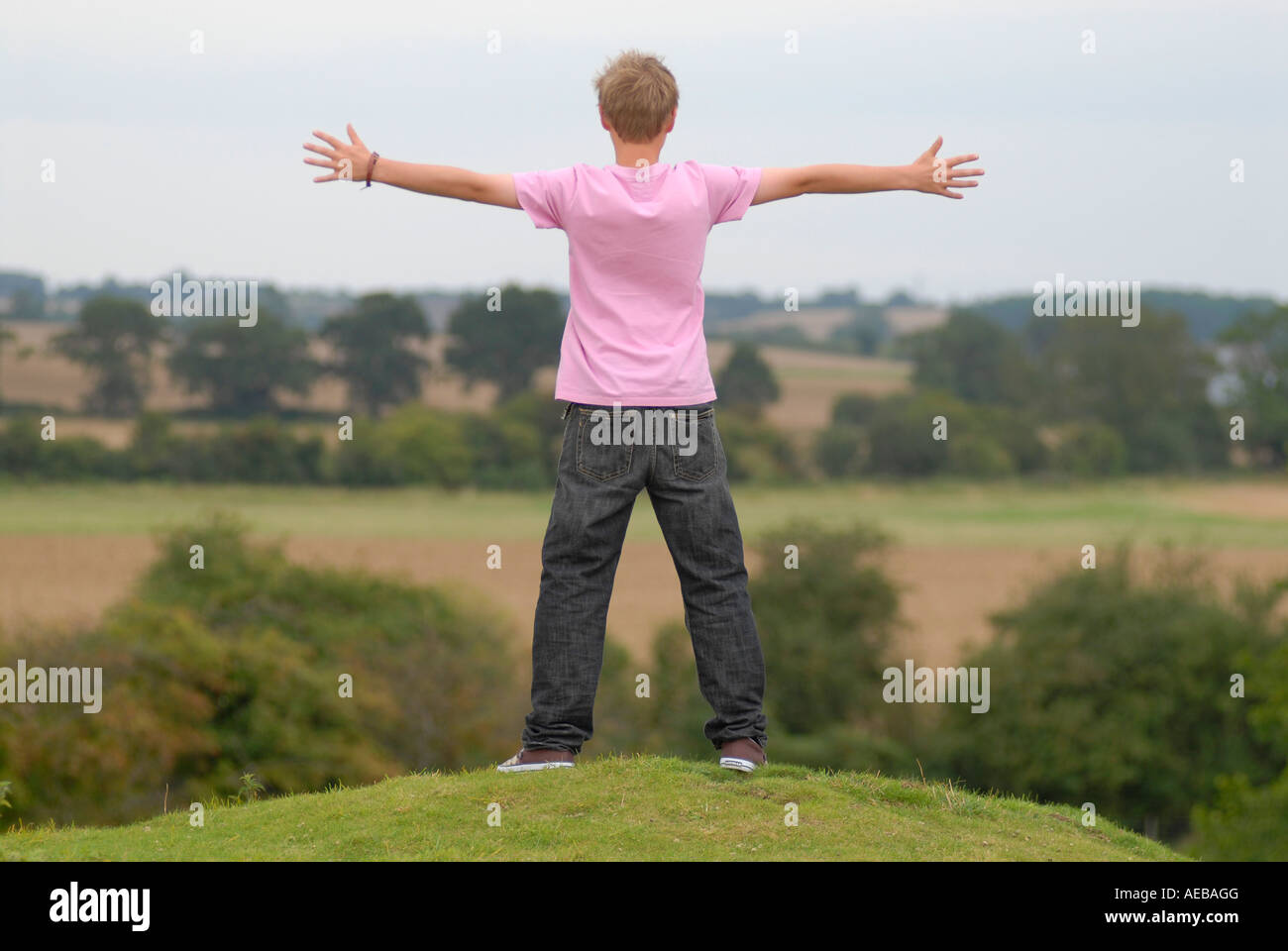 A young man aged 14yrs old feeling on top of the world after life coaching sessions in the UK Stock Photo