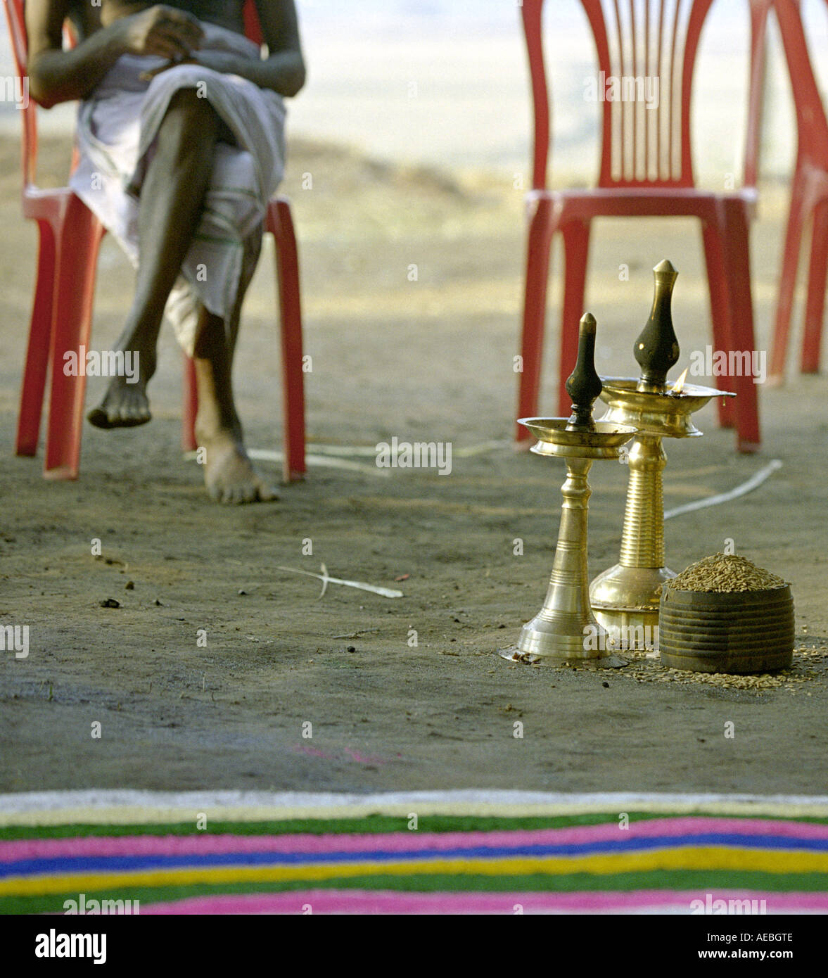 Old man sits beside a traditional ritual in a hindu temple in Kerala ...