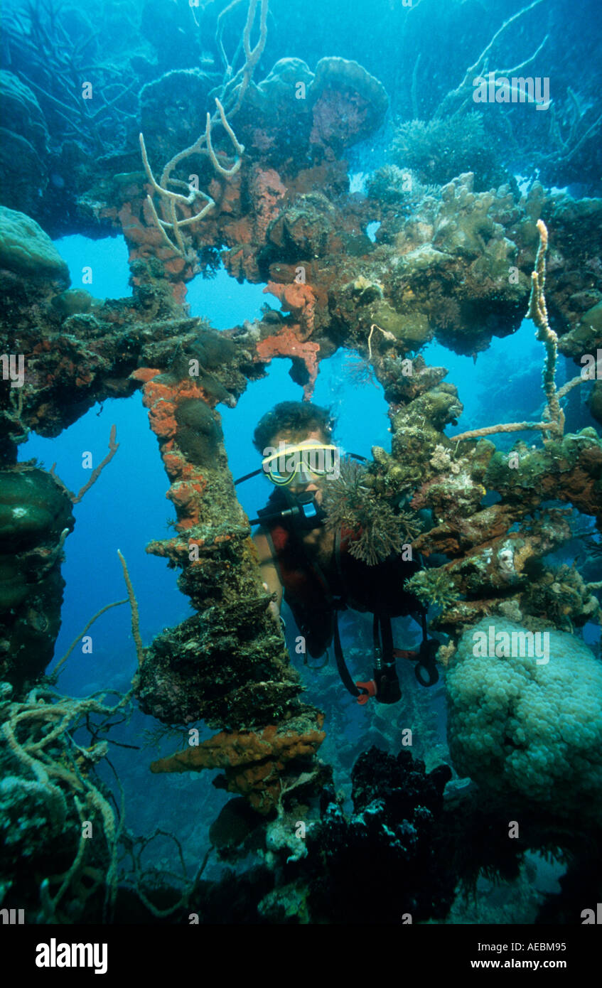 Diver Gunter Bernert and superstructure of the shallow water wreck ex woodern fishing boat Coron Island Palawan Philippines Paci Stock Photo