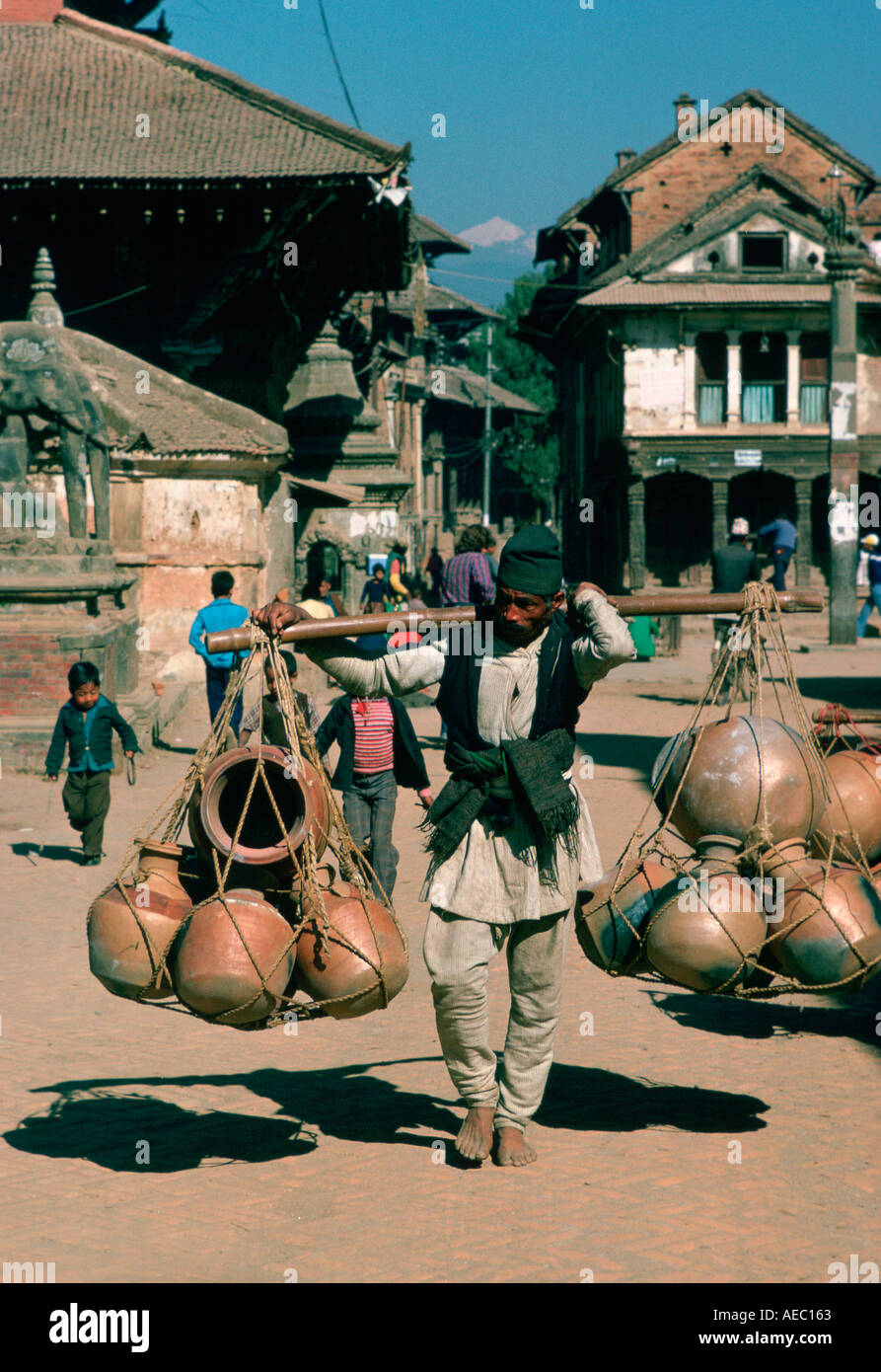 Man carrying heavy pots on shoulder hoist Patan Nepal Stock Photo Alamy