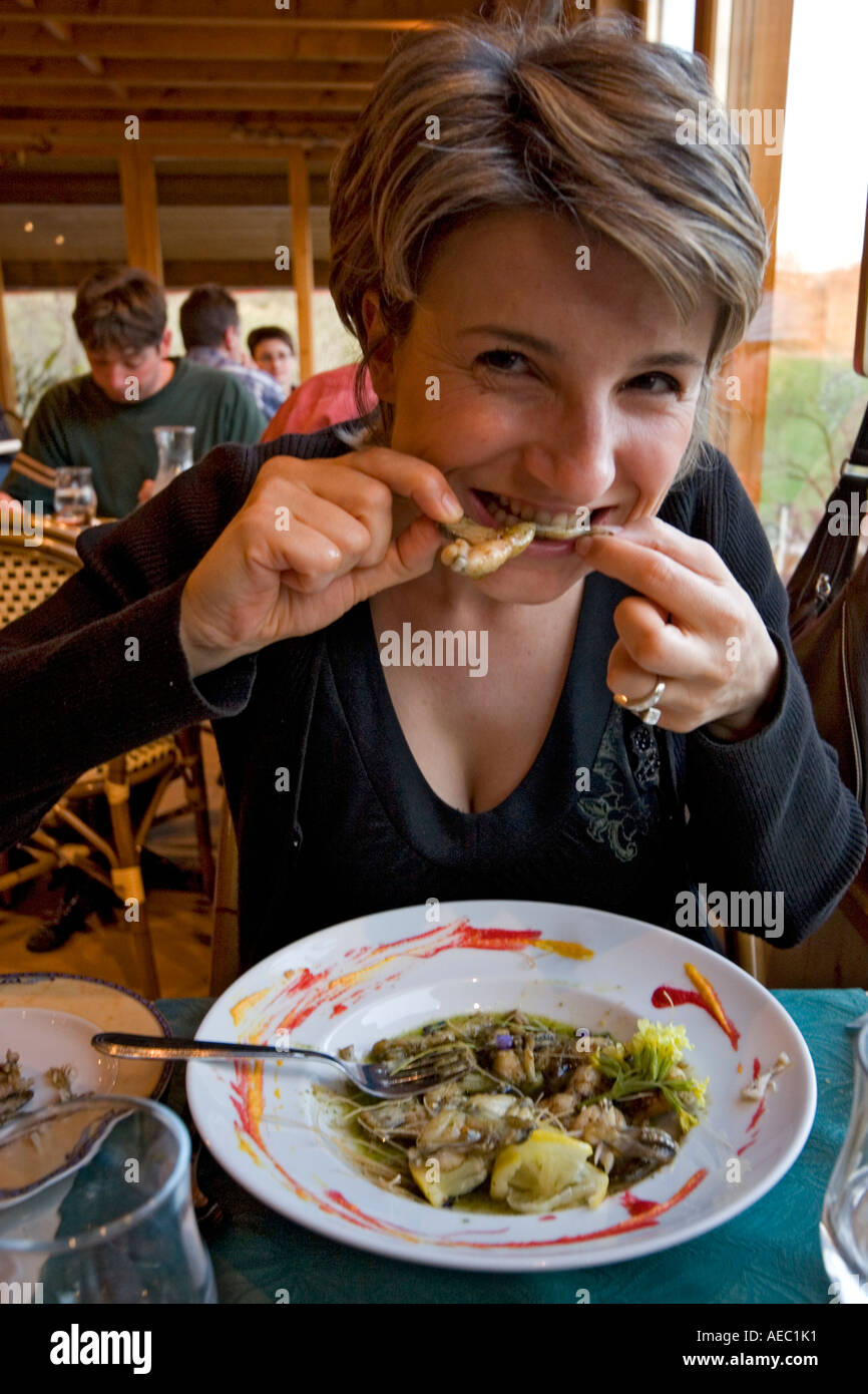 A young French Lady delighting in frog's thighs (France). Jeune femme se délectant de cuisses de grenouilles (France). Stock Photo