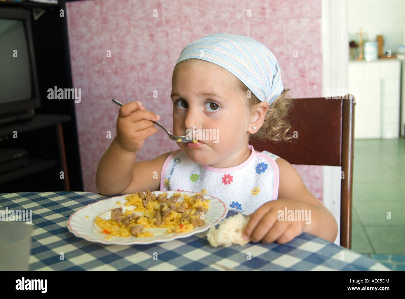 Small child eating at the lunch table, Spain Stock Photo