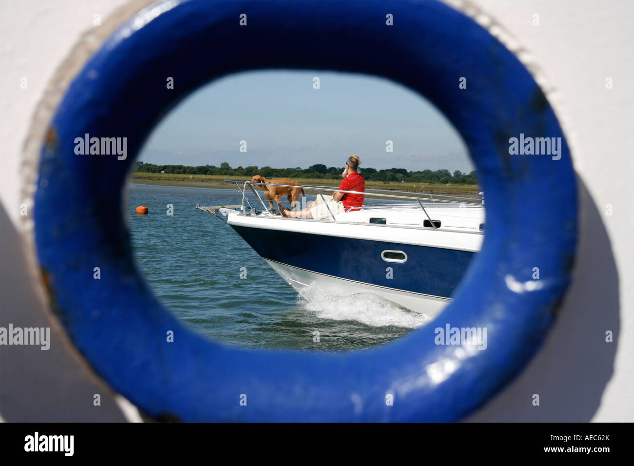 Dog, child and a man sailing, as viewed through a porthole Stock Photo