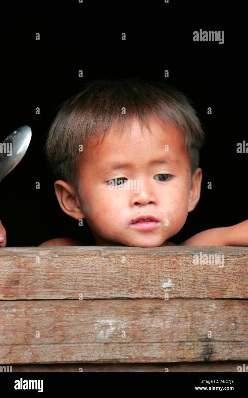 Native child at a window in a minority village on the Bolaven Plateau