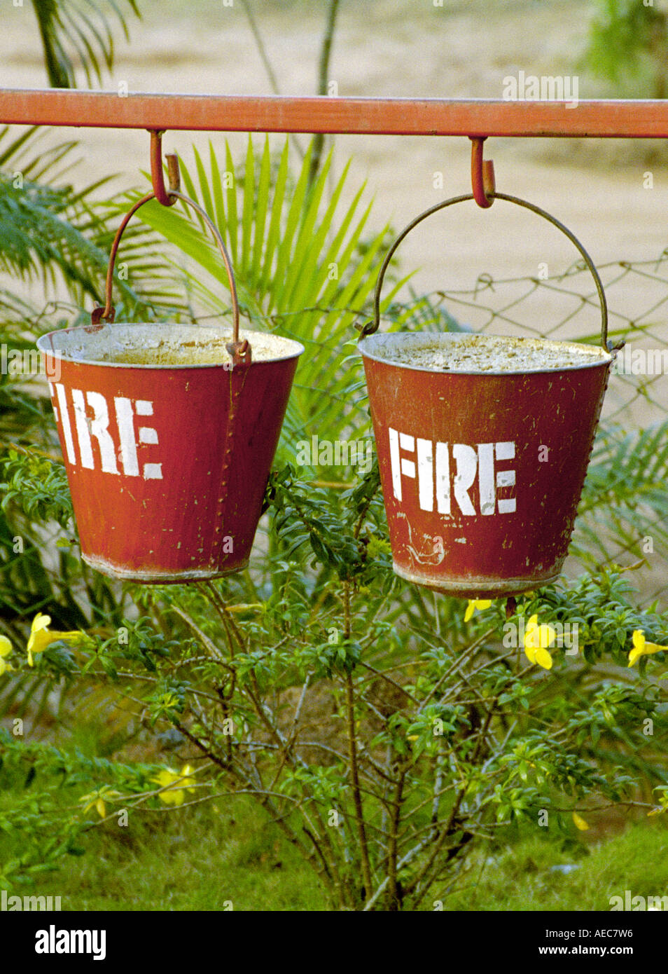 Two red buckets filled with sand and painted Fire hanged serially near a petrol bunk in Kerala India Stock Photo
