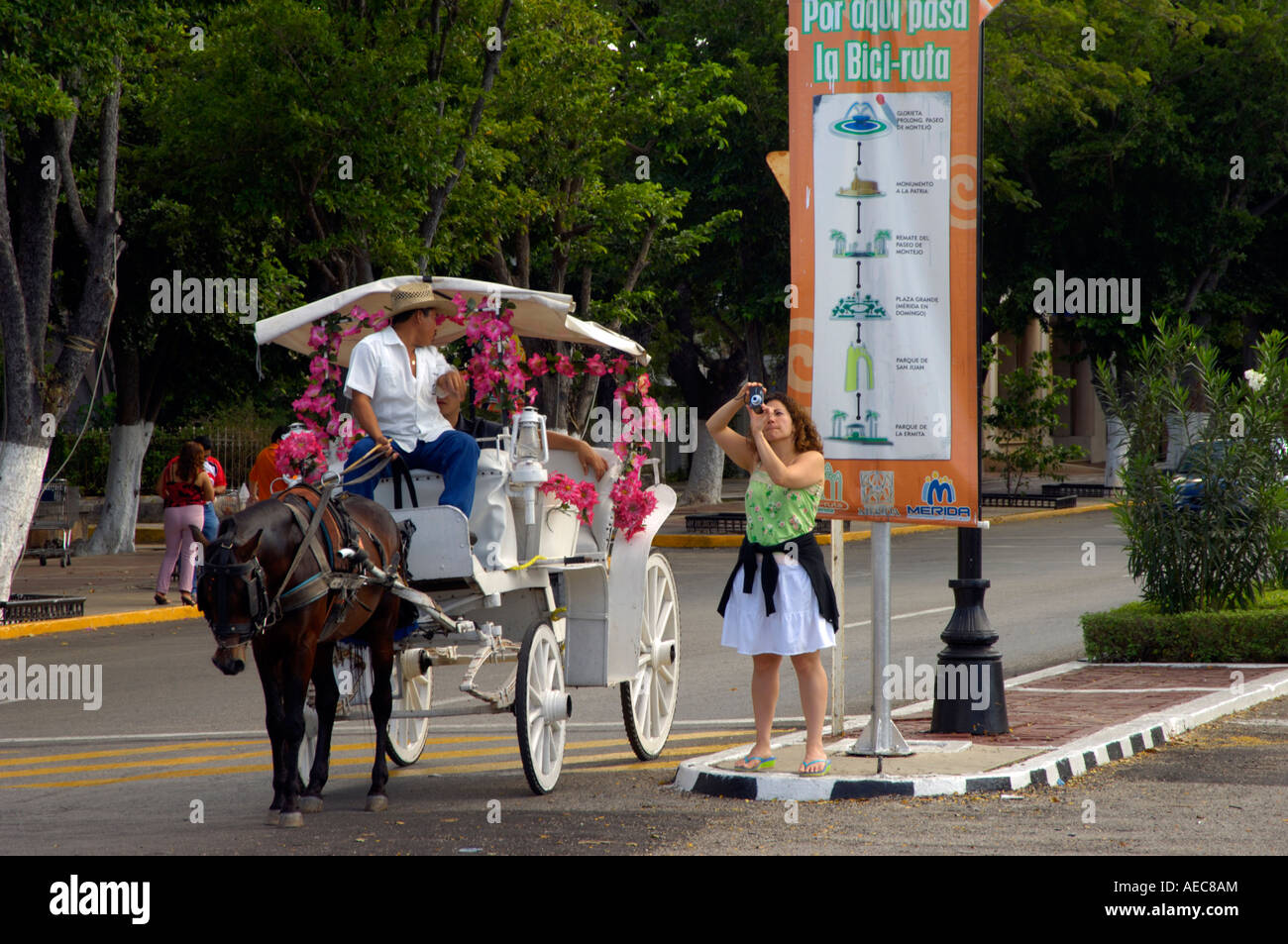 A young woman stops her carriage to take a photograph of Monumento a la Bandera in Merida Stock Photo