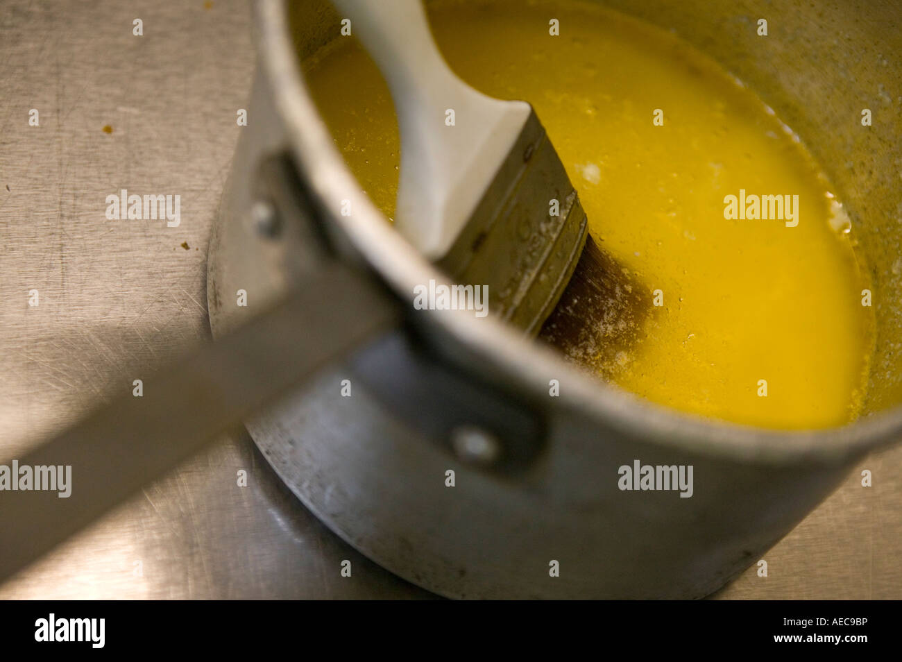 Melted butter and brush in a tin saucepan on a metal kitchen surface