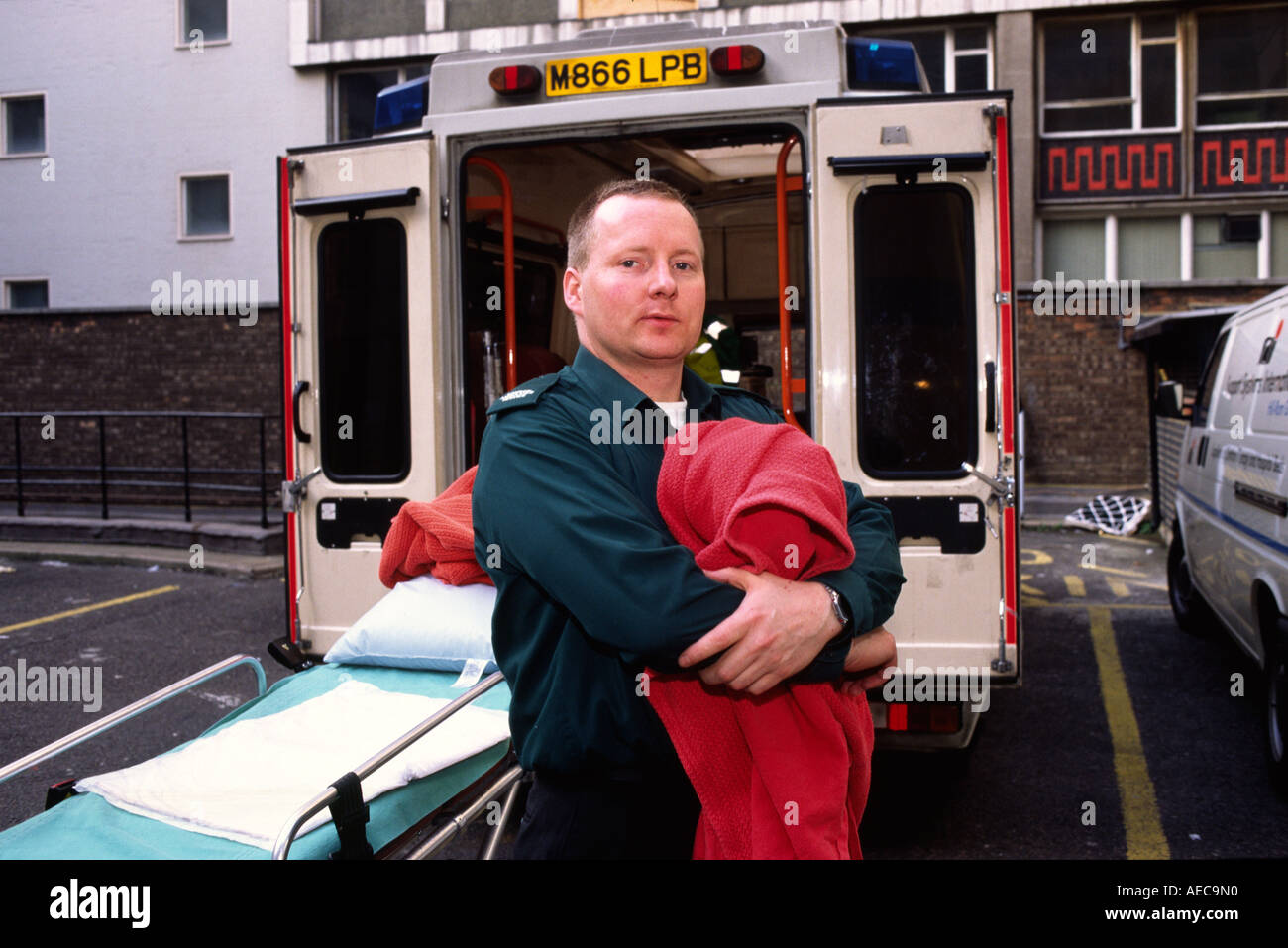 A portrait of London ambulance crew member with a blanket behind his emergency ambulance Stock Photo