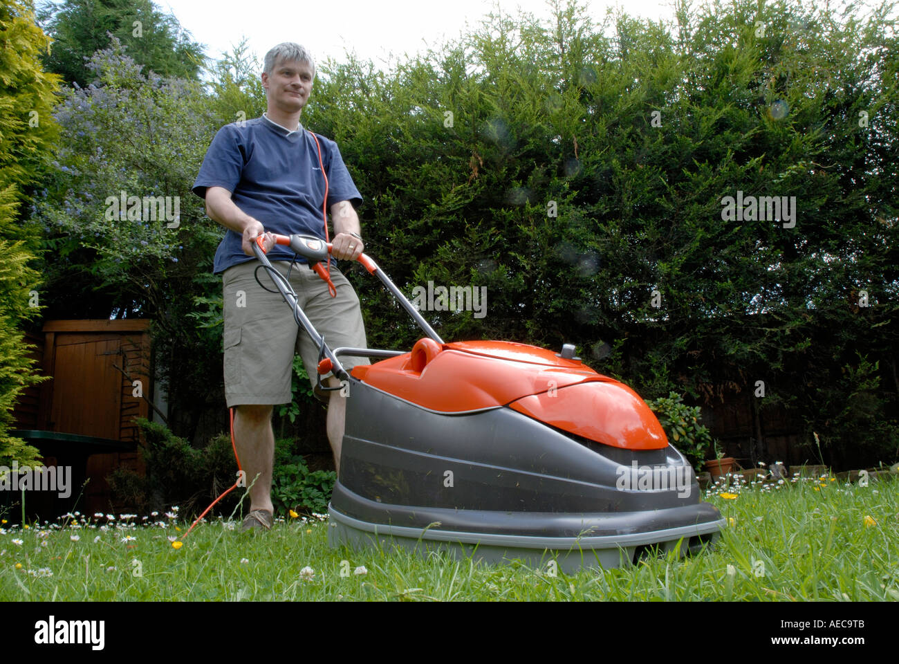 Man Cutting Lawn with Flymo Lawnmower Stock Photo