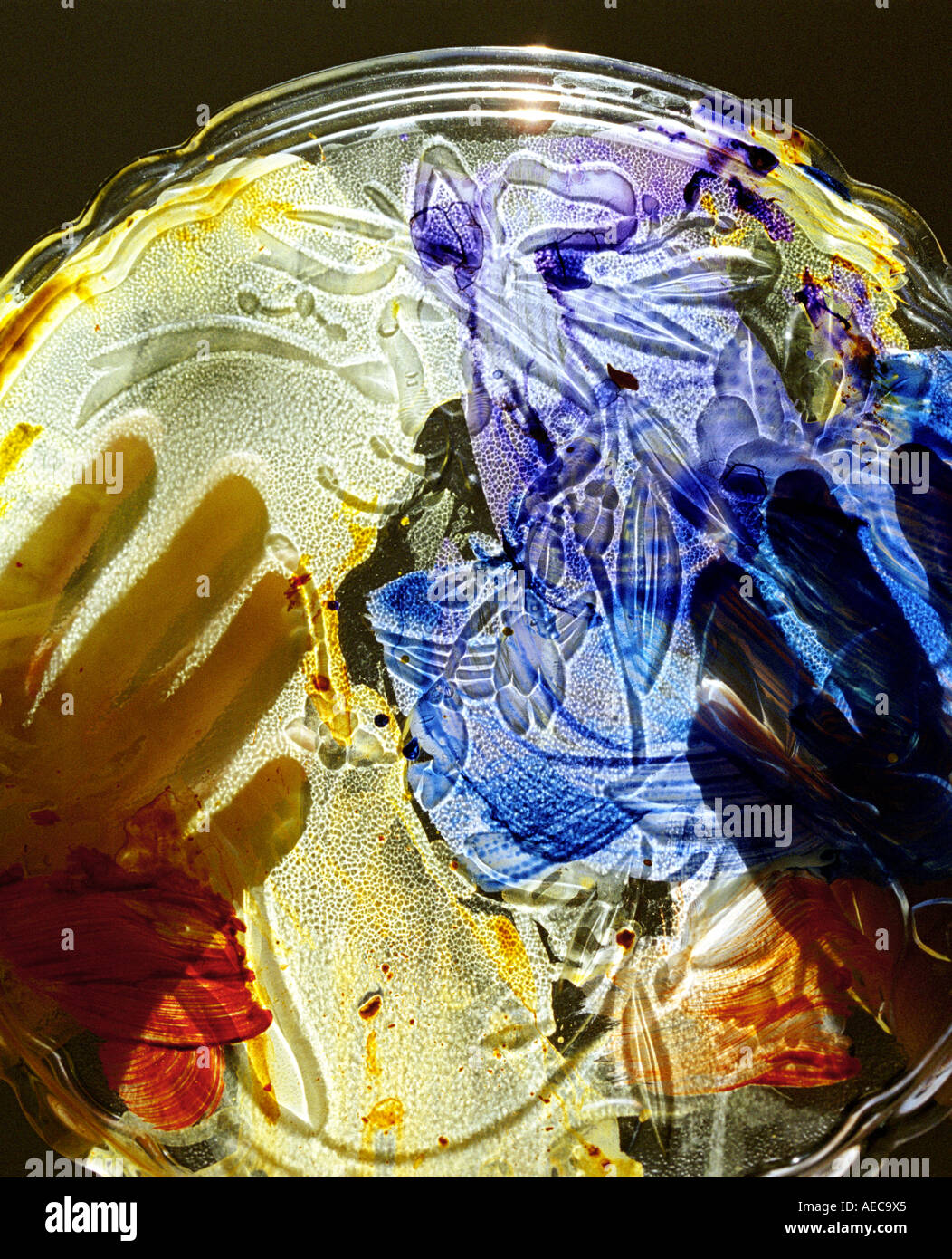 Abstract composition with painted glass held in both hands with back lighting, vertical composition Stock Photo