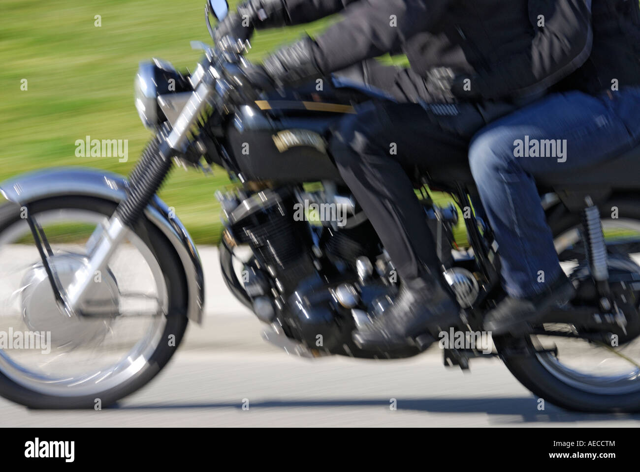 'Couple riding a modified and updated ^1950s Vincent Rapide ^998cc V twin ^motorcycle. (Speed blur.)' Stock Photo