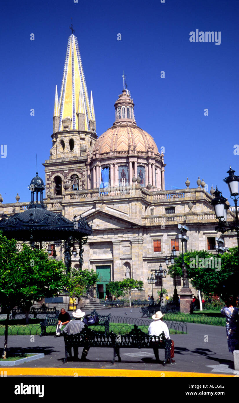 A street scene in the central plaza of Guadalajara Mexico Two men sit on a bench in front of the central cathedral Stock Photo