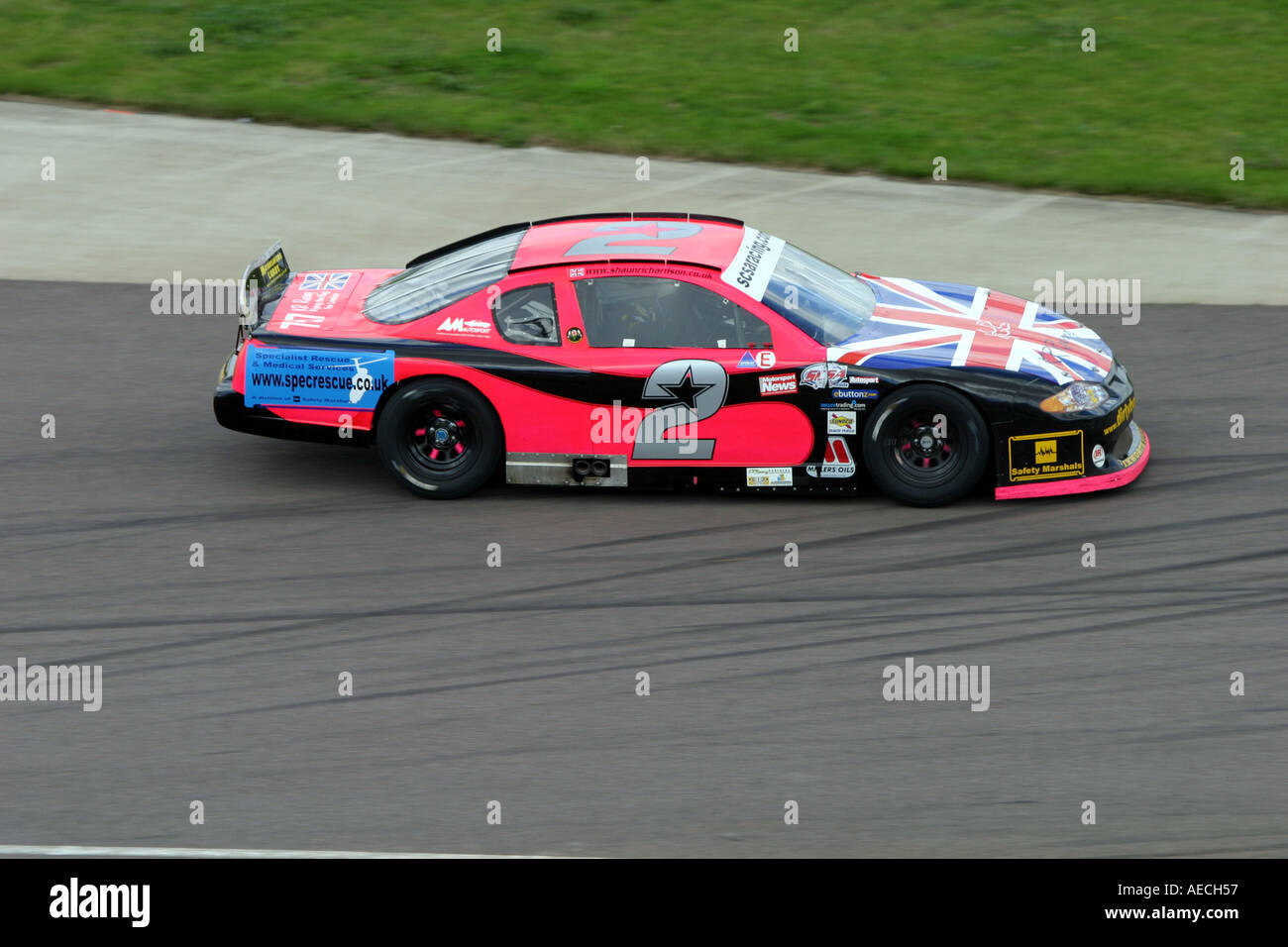 V8 Nascar type stock cars racing on a banked oval circuit Stock Photo