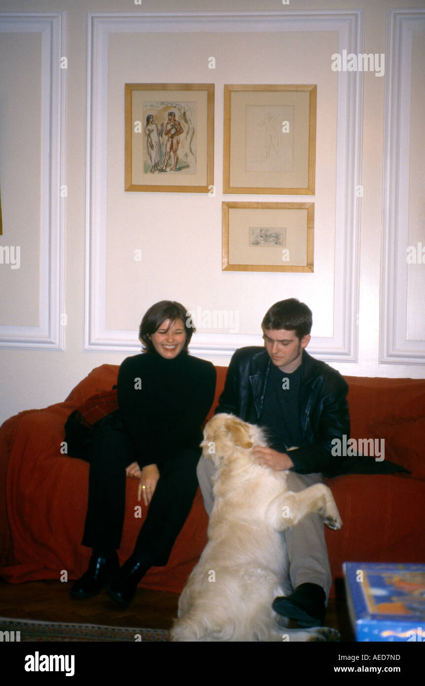 Young Couple Sitting on Sofa with Dog Stock Photo