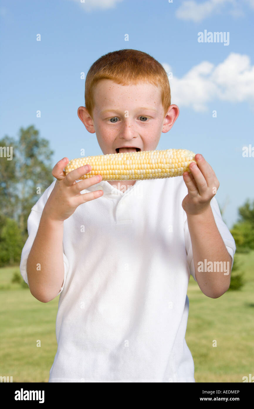 A Boy Looks Very Excited To Eat Corn On The Cob Stock Photo Alamy