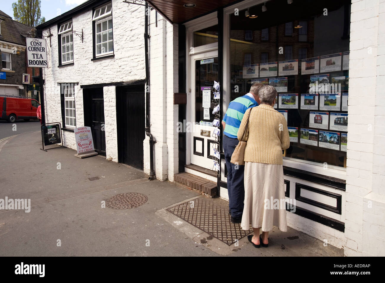 UK Wales Powys Builth Wells High Street middle aged couple looking into Estate Agents window Stock Photo