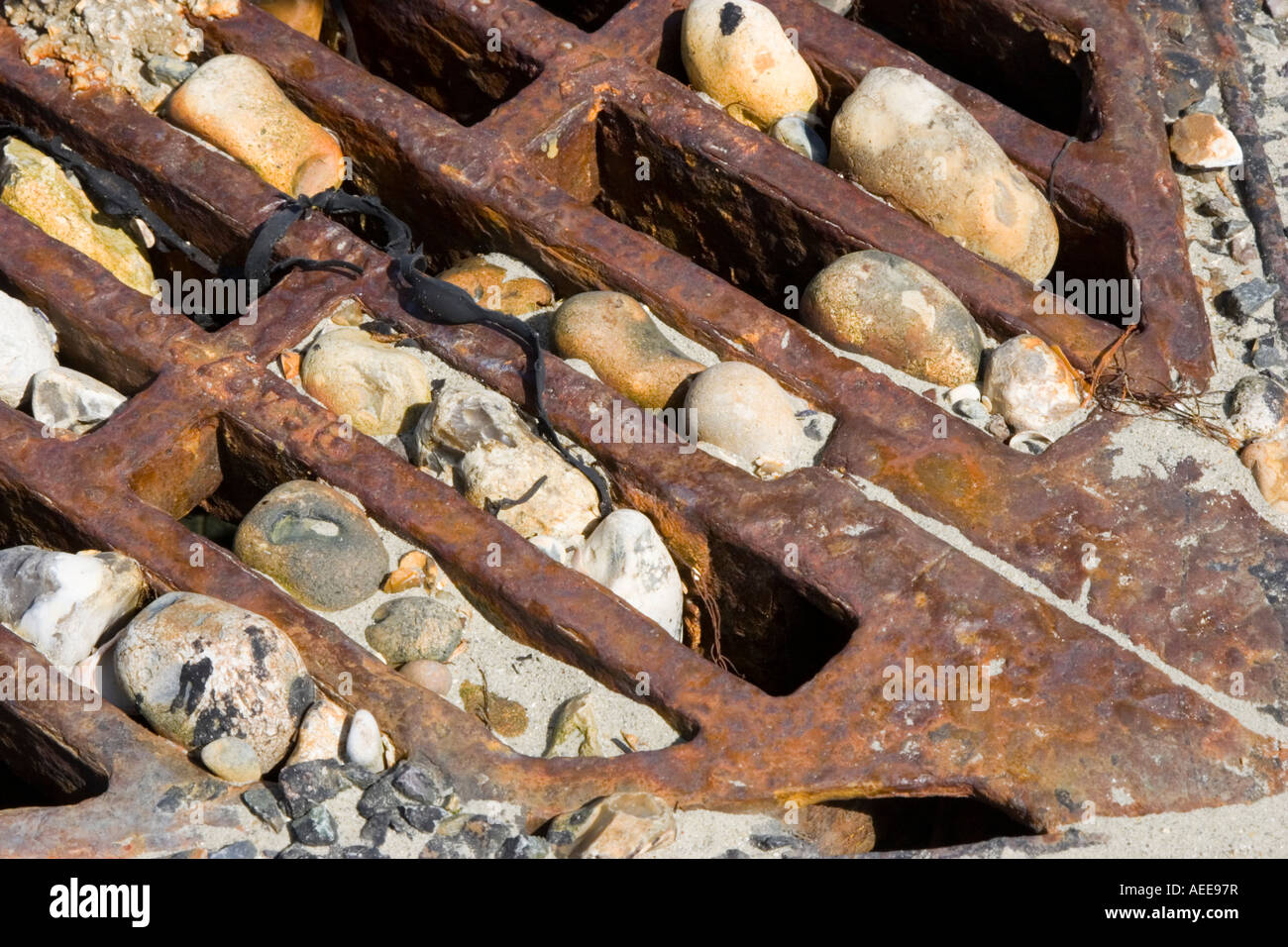 Pebbles wedged in the grate of a storm drain Stock Photo