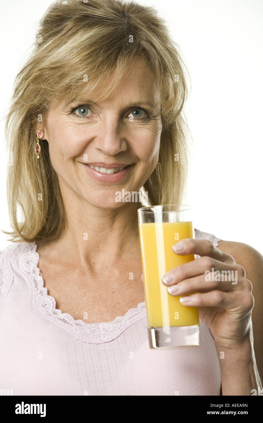 A woman smiling while holding a glass of juice Stock Photo - Alamy