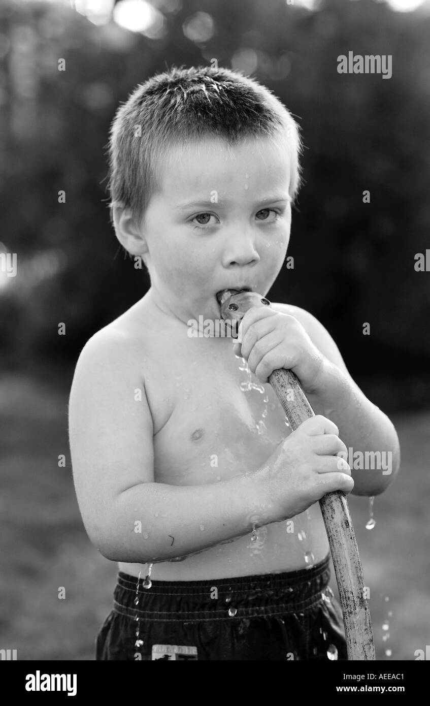 young boy with hose in mouth Stock Photo