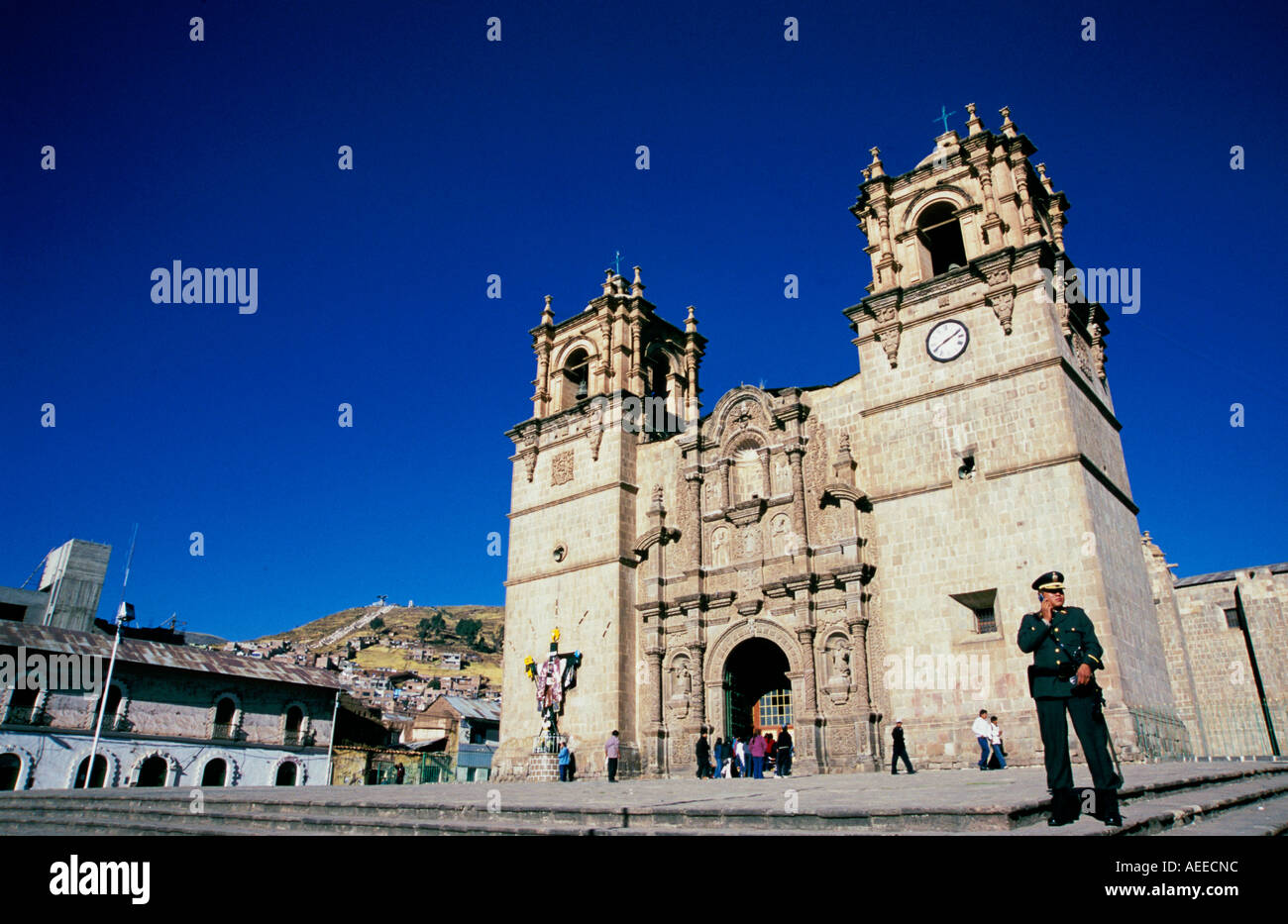 A Policeman talking on a mobile telephone outside Puno Cathedral, Peru Stock Photo