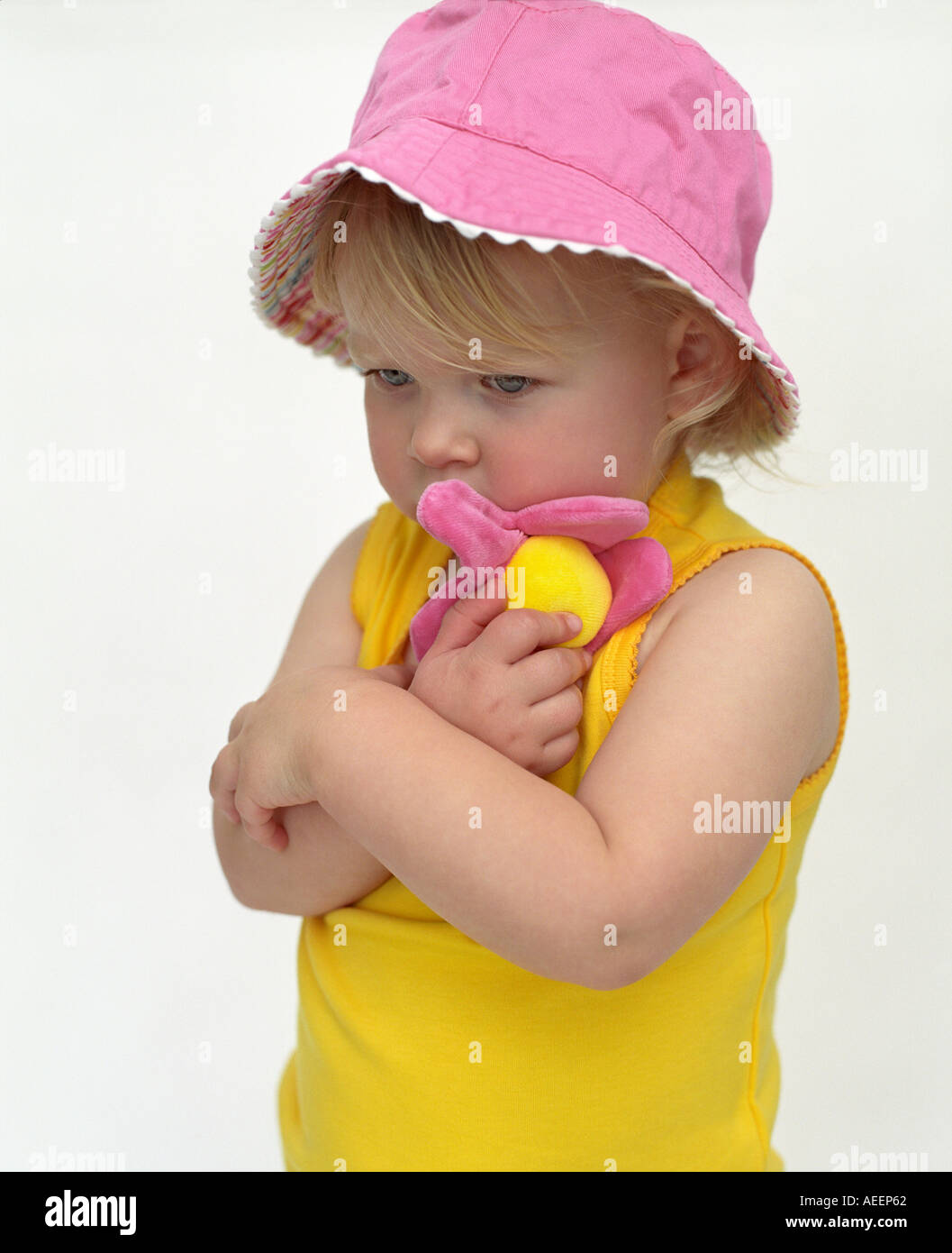 little girl wearing pink hat hugging cuddly toy Stock Photo Alamy