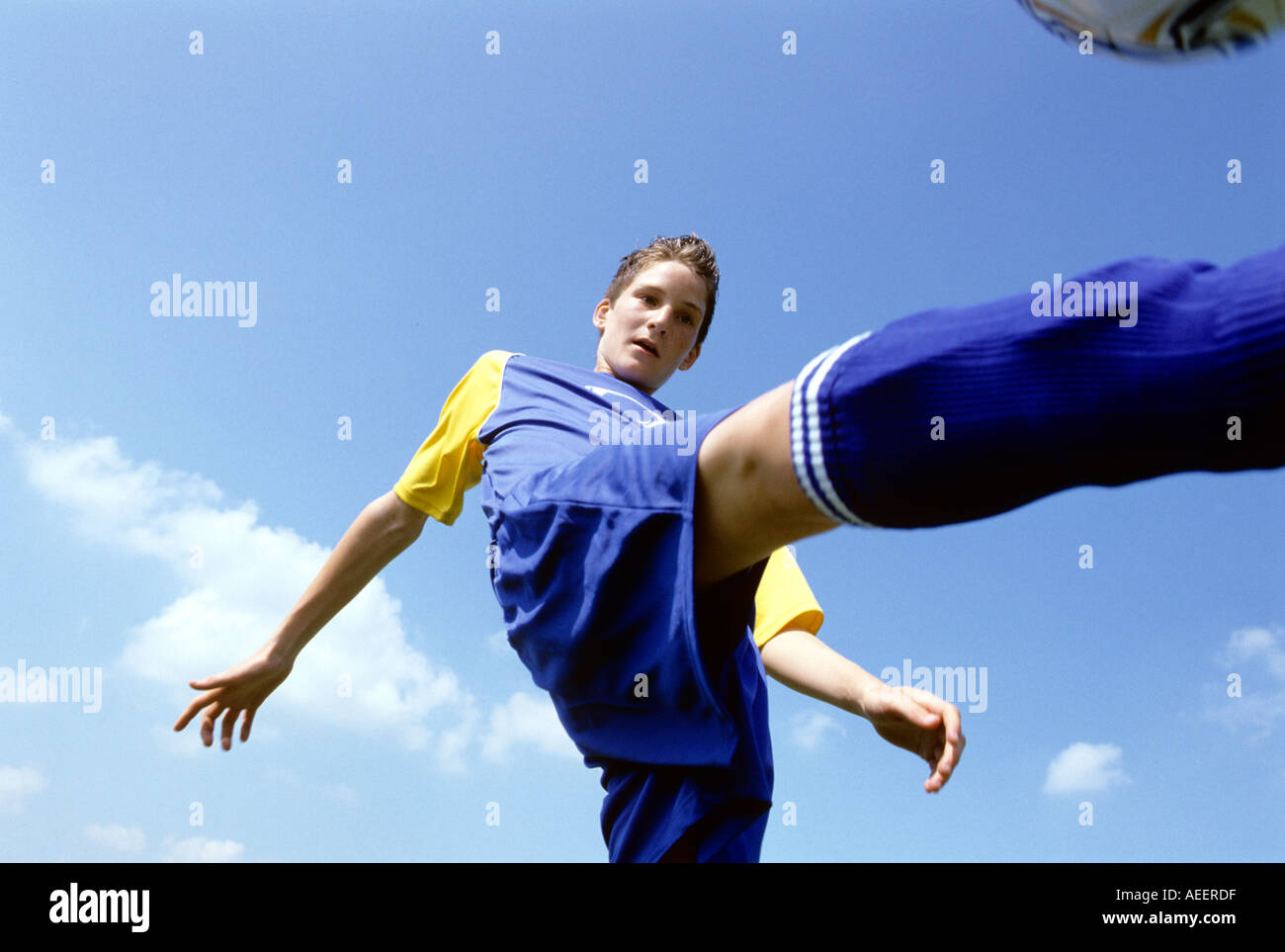 teenage football player kicking the ball Stock Photo Alamy