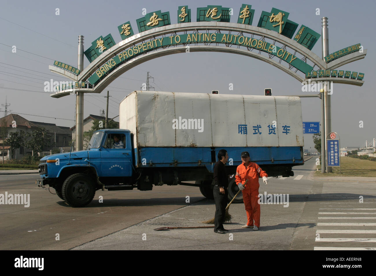 Shanghai China A street cleaner directs a lost motorist to Anting Automobile City Stock Photo