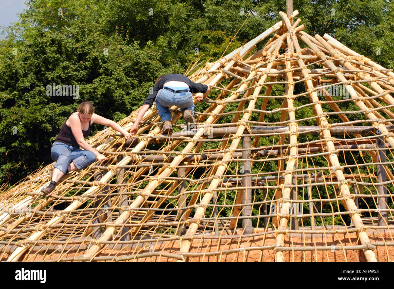 Volunteers work to construct an Iron Age roundhouse using traditional