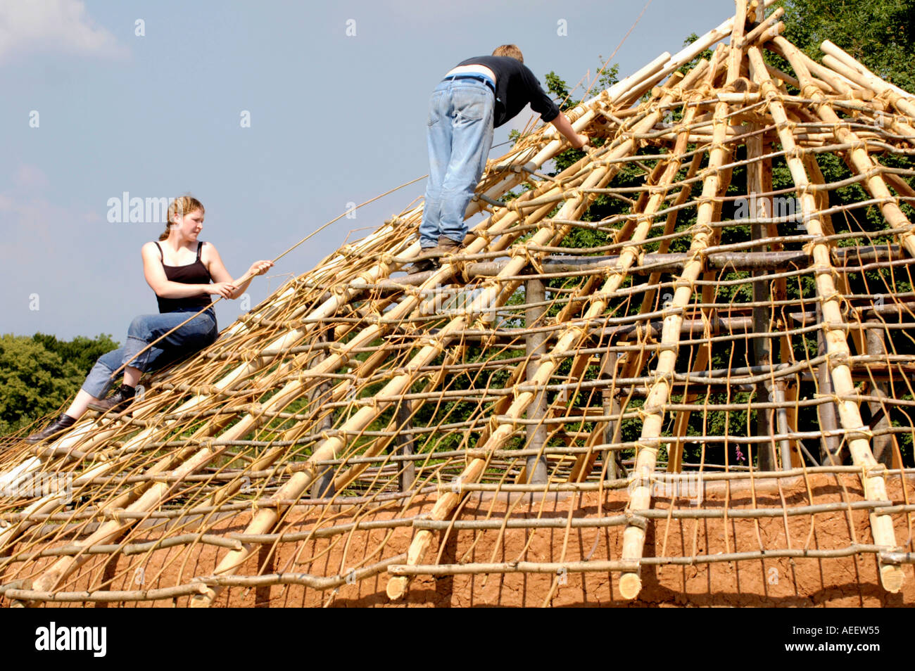 Volunteers work to construct an Iron Age roundhouse using traditional