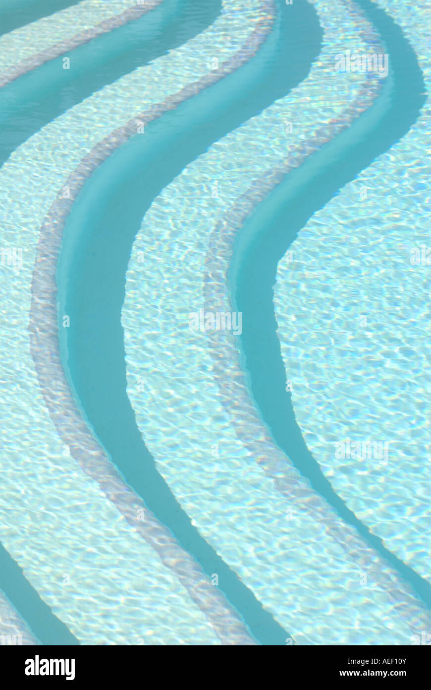 Contemporary patterned bold image of swimming pool steps seen above the water Stock Photo