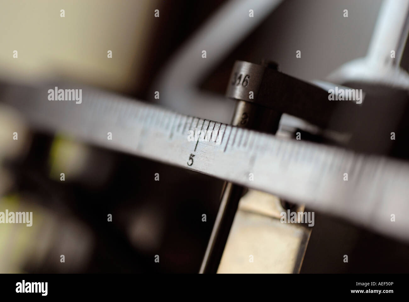 Slider of a mechanical balance scale marking number five Stock Photo