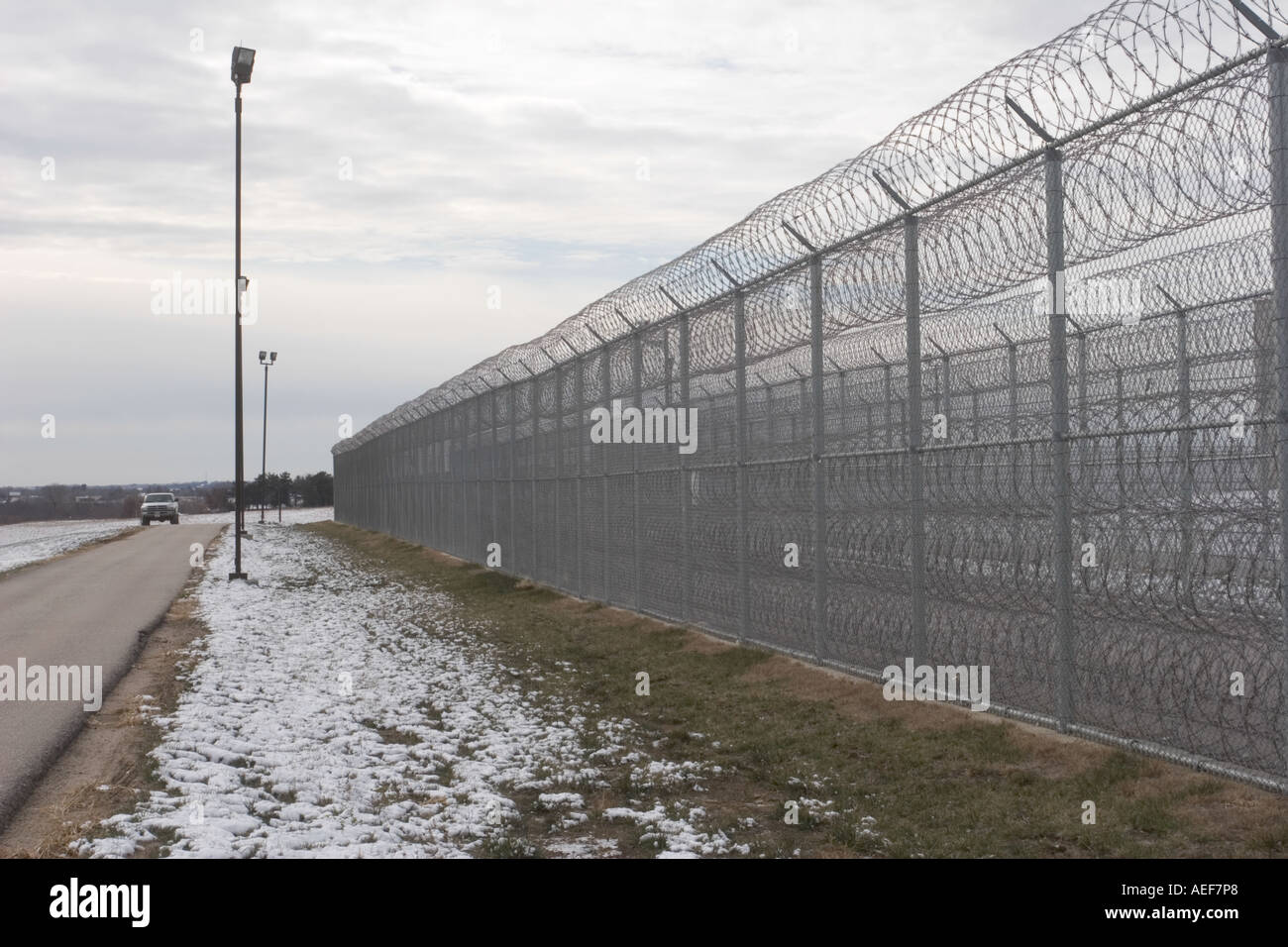 Perimeter fence with patrolling vehicle for added security Tecumseh State Correctional Institution Tecumseh Nebraska USA Stock Photo