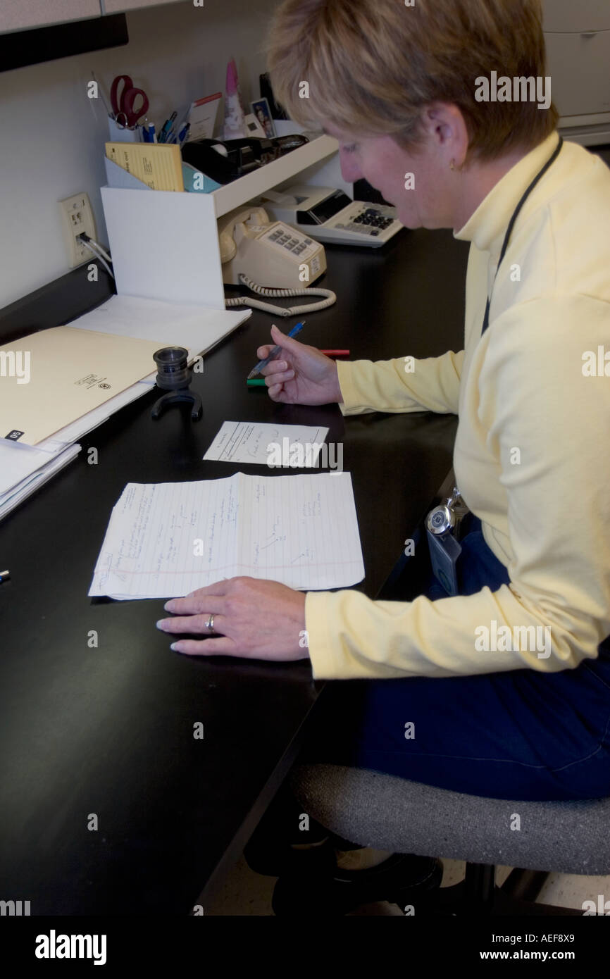Forensic handwriting expert is comparing two handwriting samples side by side Nebraska State Patrol Crime Lab, USA. Stock Photo